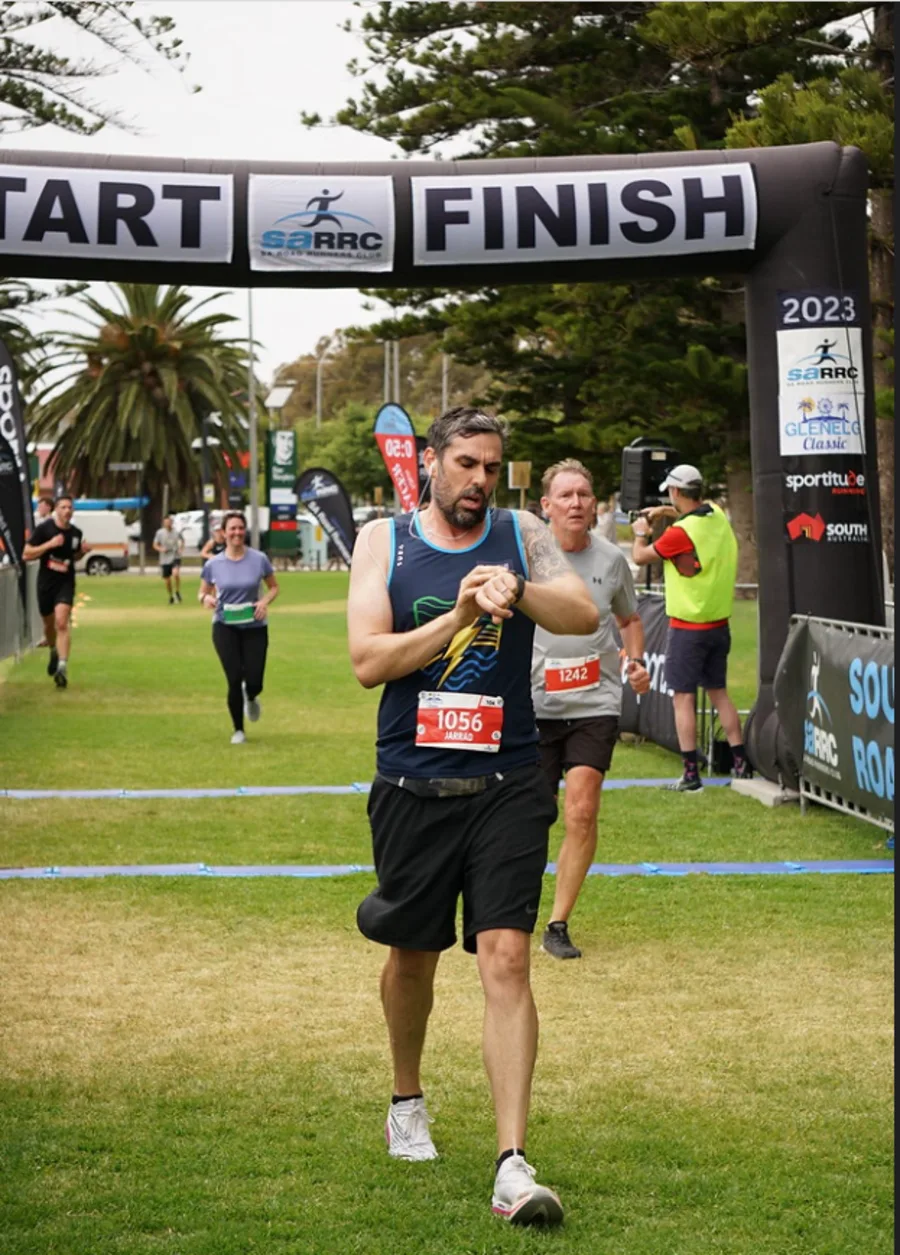 Jarrad Goulding crossing the finish line at a previous marathon race, demonstrating the culmination of months of dedicated training and preparation