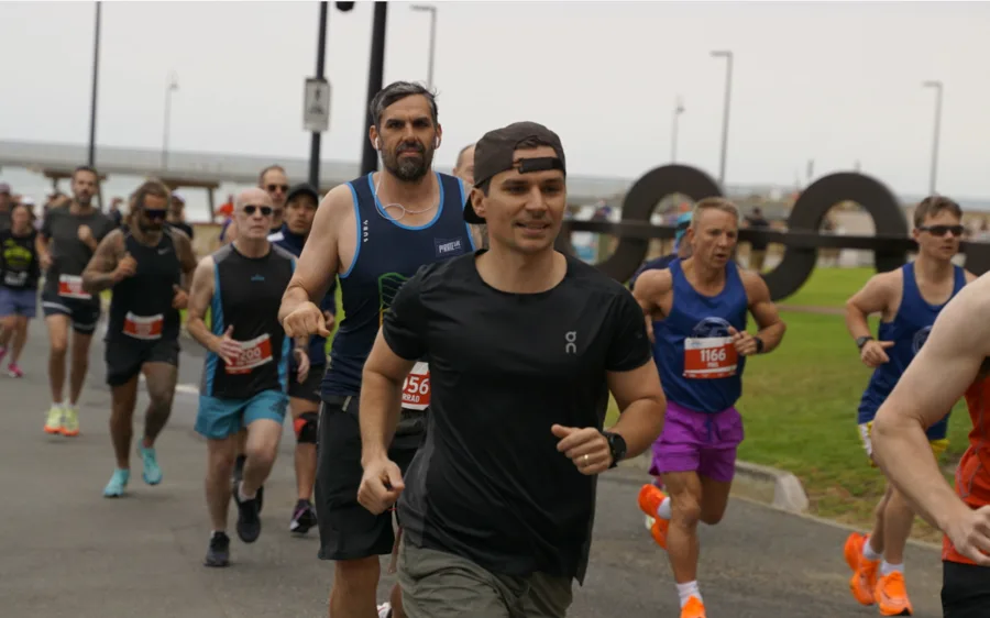 Jarrad Goulding running alongside fellow competitors, showing the community and accountability that drives marathon training success